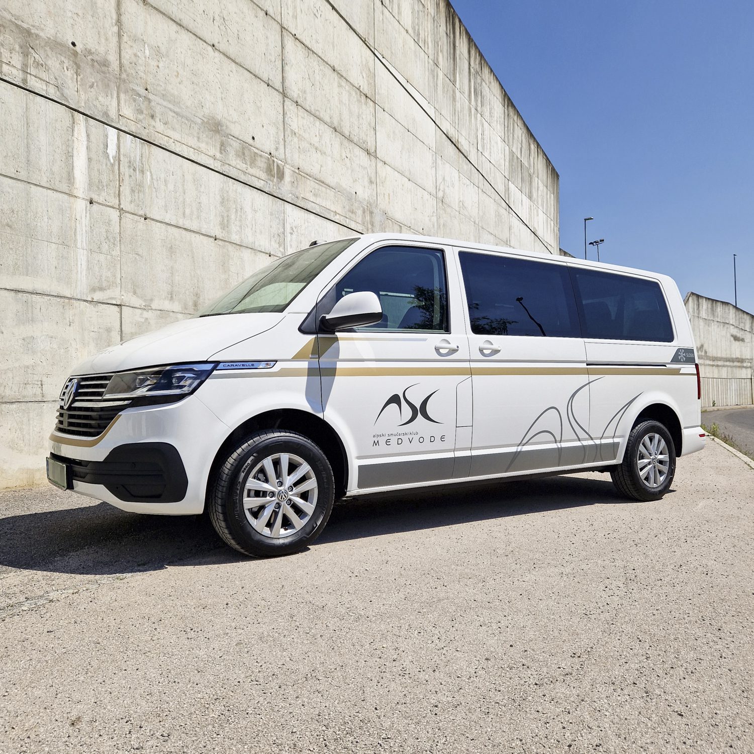 Polepitev dostavnega vozila Volkswagen Caravelle za ASK Medvode, izvedeno s strani Styxz. Sodobna grafična polepitev vozila. Sodobna grafična polepitev vozila.